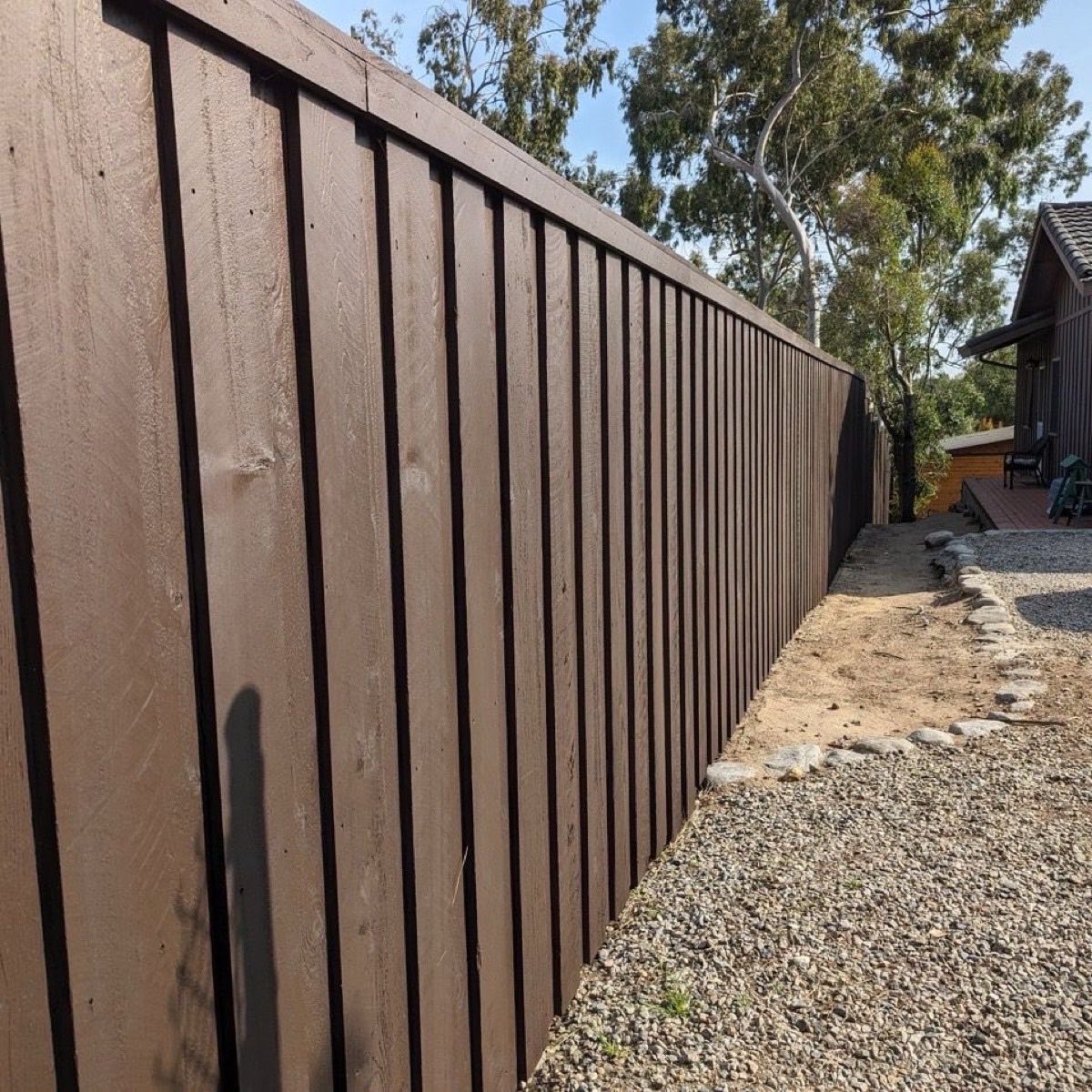 Dark brown board-on-board wood privacy fence enclosing a residential yard